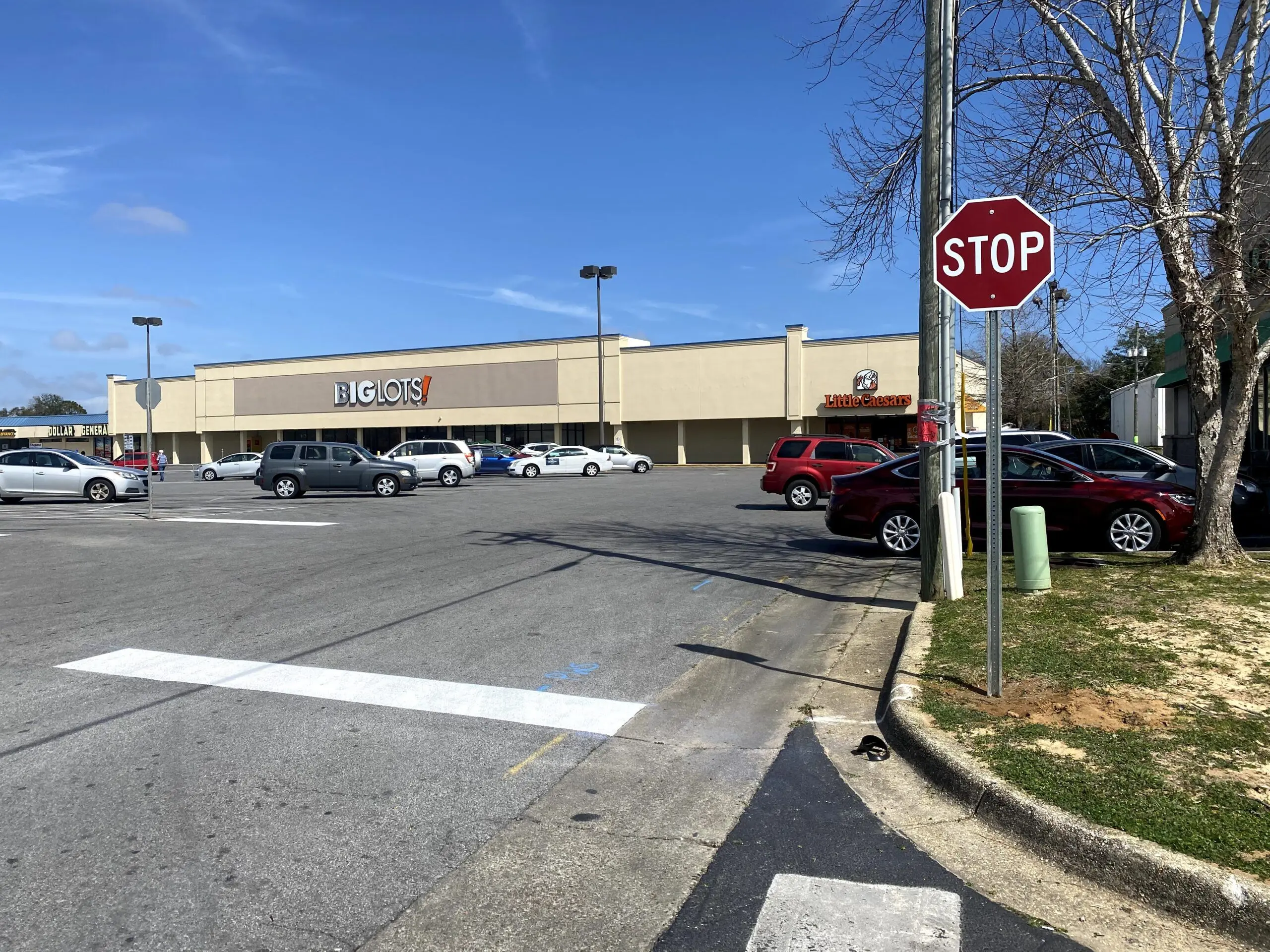 Stop sign with freshly painted stop line and curb markings in a commercial parking lot